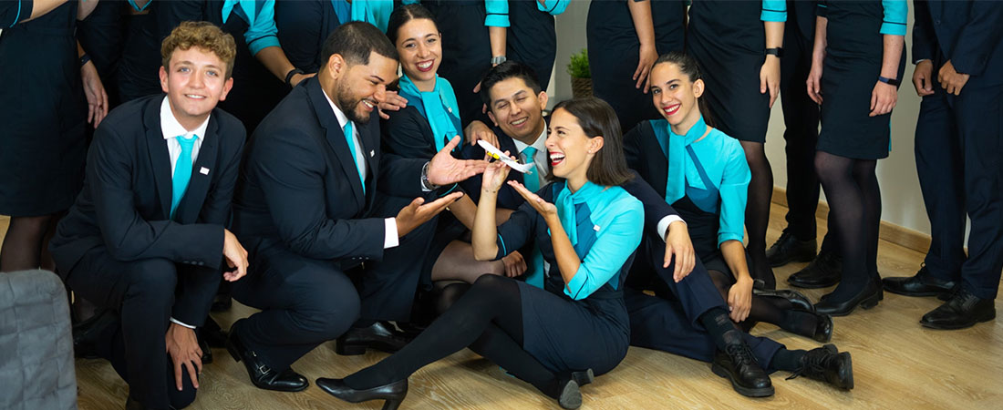 Alumnos TCP sentados en el suelo tomándose una foto riendo.