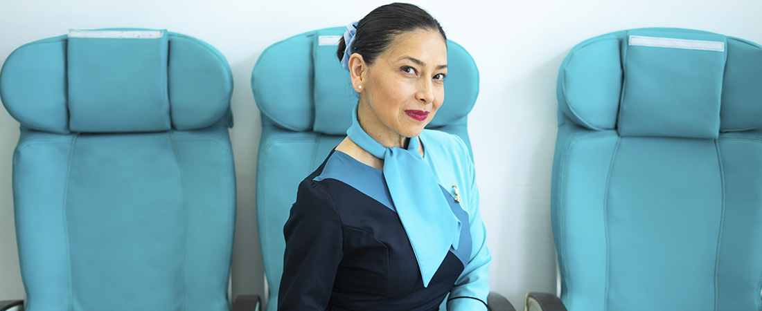 Tripulante de cabina preparando su maleta de forma organizada para un vuelo.