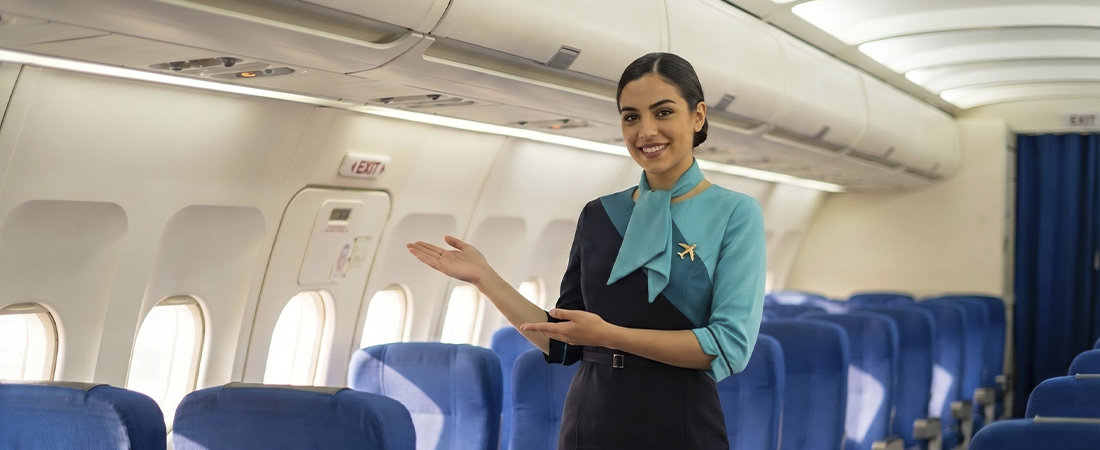 TCP sonriendo dando la bienvenida en la cabina de un avión.